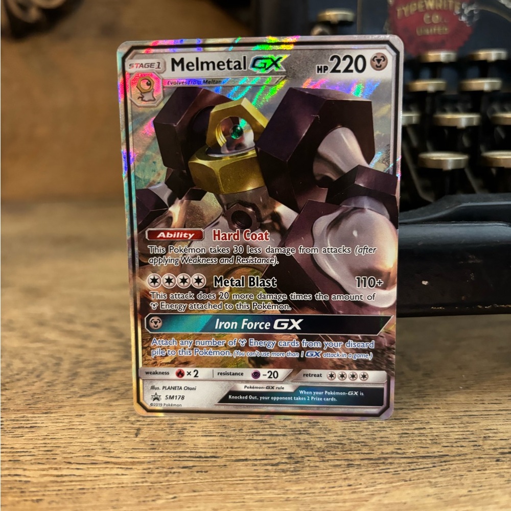 Pokemon Melmetal GX Trading Card - Gold and Black